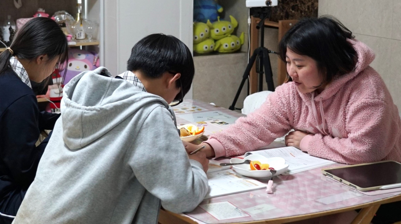 Han Si-nae teaches her students at her home in Daegu. (Song Seung-hyun/The Korea Herald)