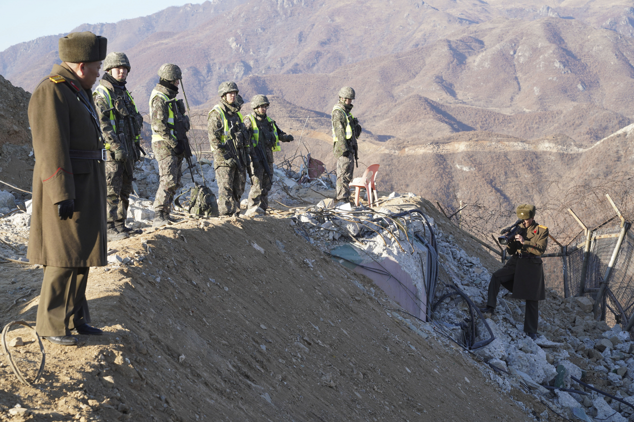 A South Korean and North Korean army soldier takes a inspect at the dismantled North Korean guard post inside the Demilitarized Zone in the central section of the inter-Korean border in Cheorwon, North Korea on Dec.17, 2018. (The defense ministry)