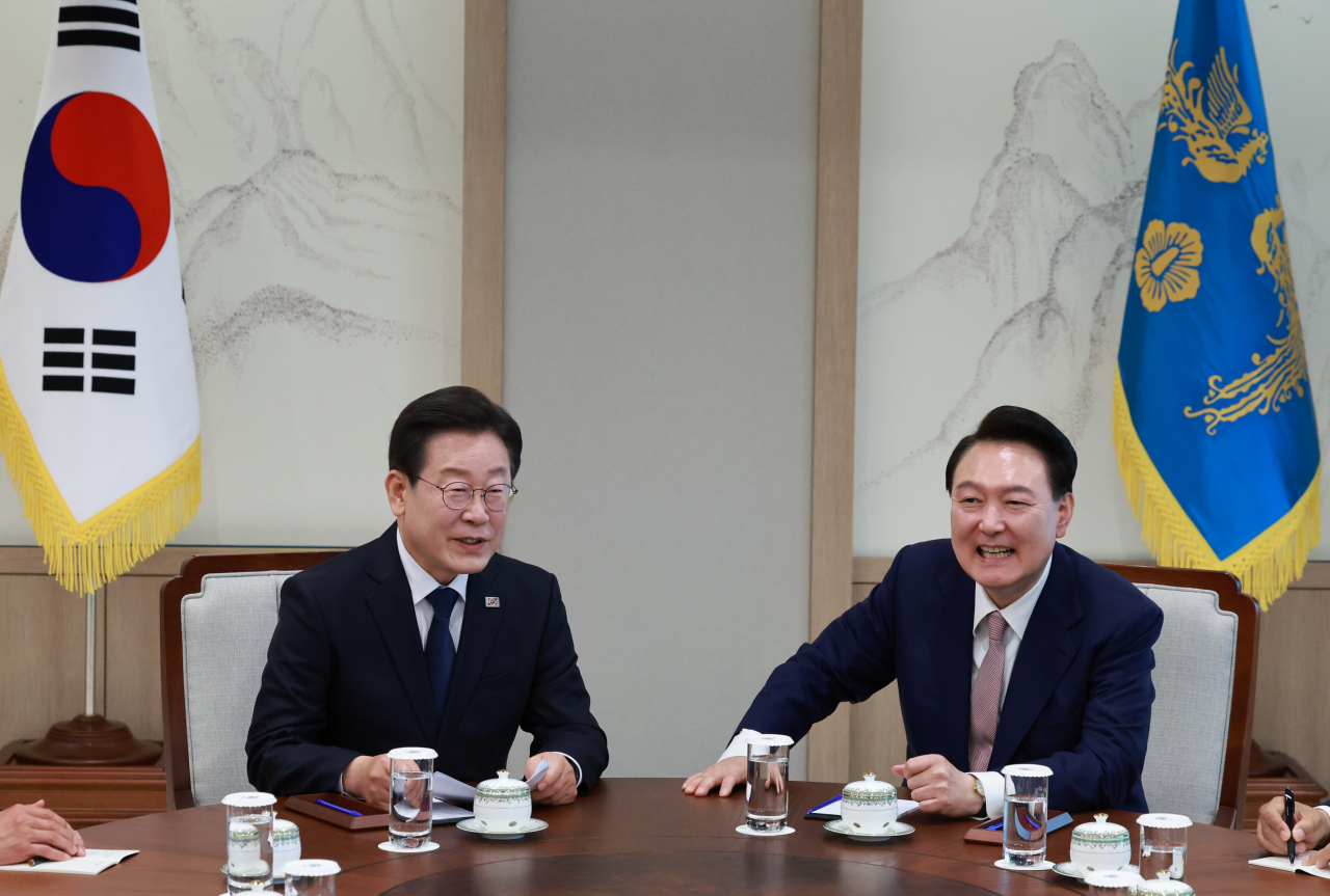 President Yoon Suk Yeol (right) and the main opposition Democratic Party of Korea leader Rep. Lee Jae-myung talk during their first meeting since Yoon was inaugurated, at the presidential office in Seoul on Monday. (Yonhap)