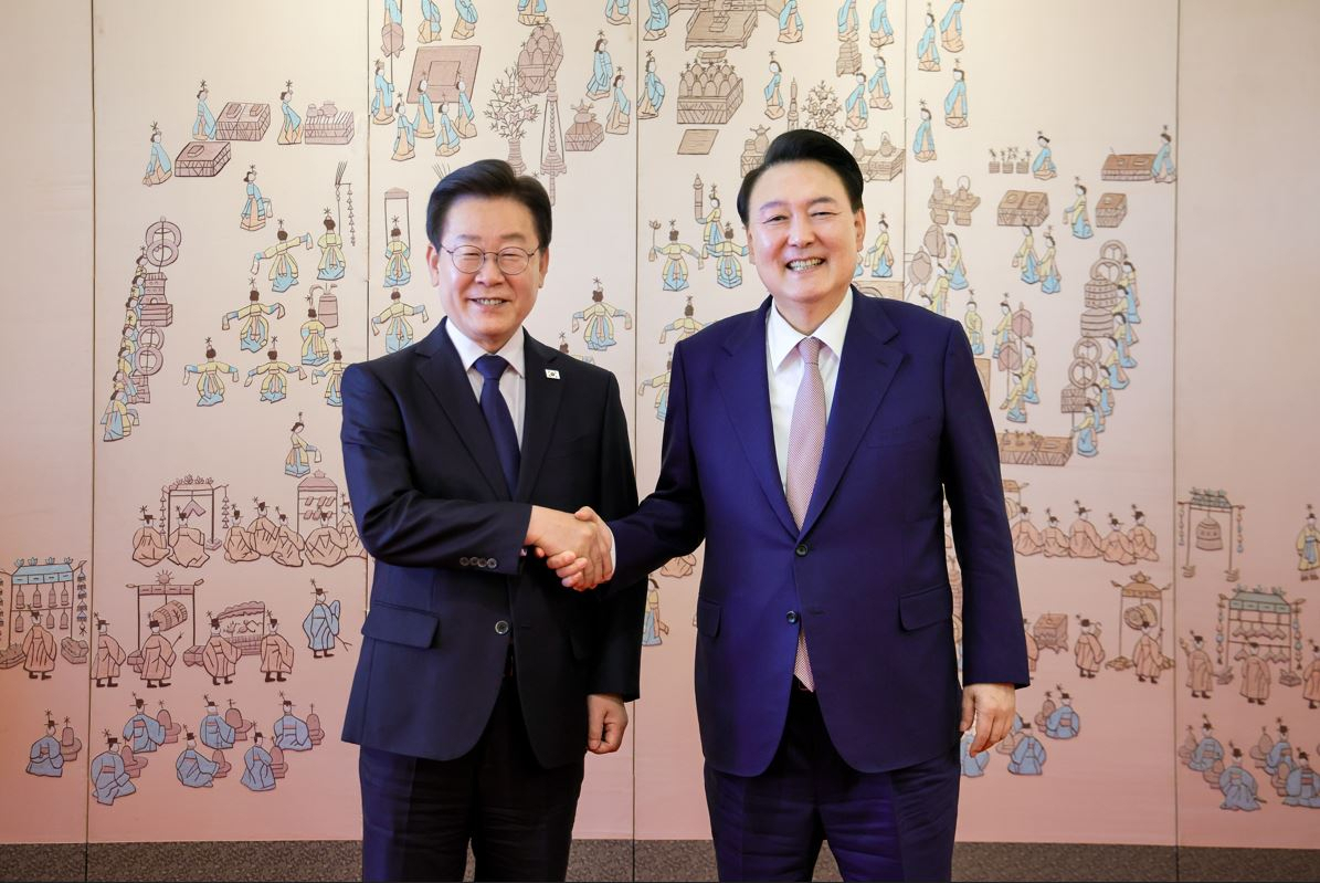 President Yoon Suk Yeol (right) and the main opposition Democratic Party of Korea leader Rep. Lee Jae-myung pose for a photo after their first meeting since Yoon was inaugurated, at the presidential office in Seoul on Monday. (Presidential office)