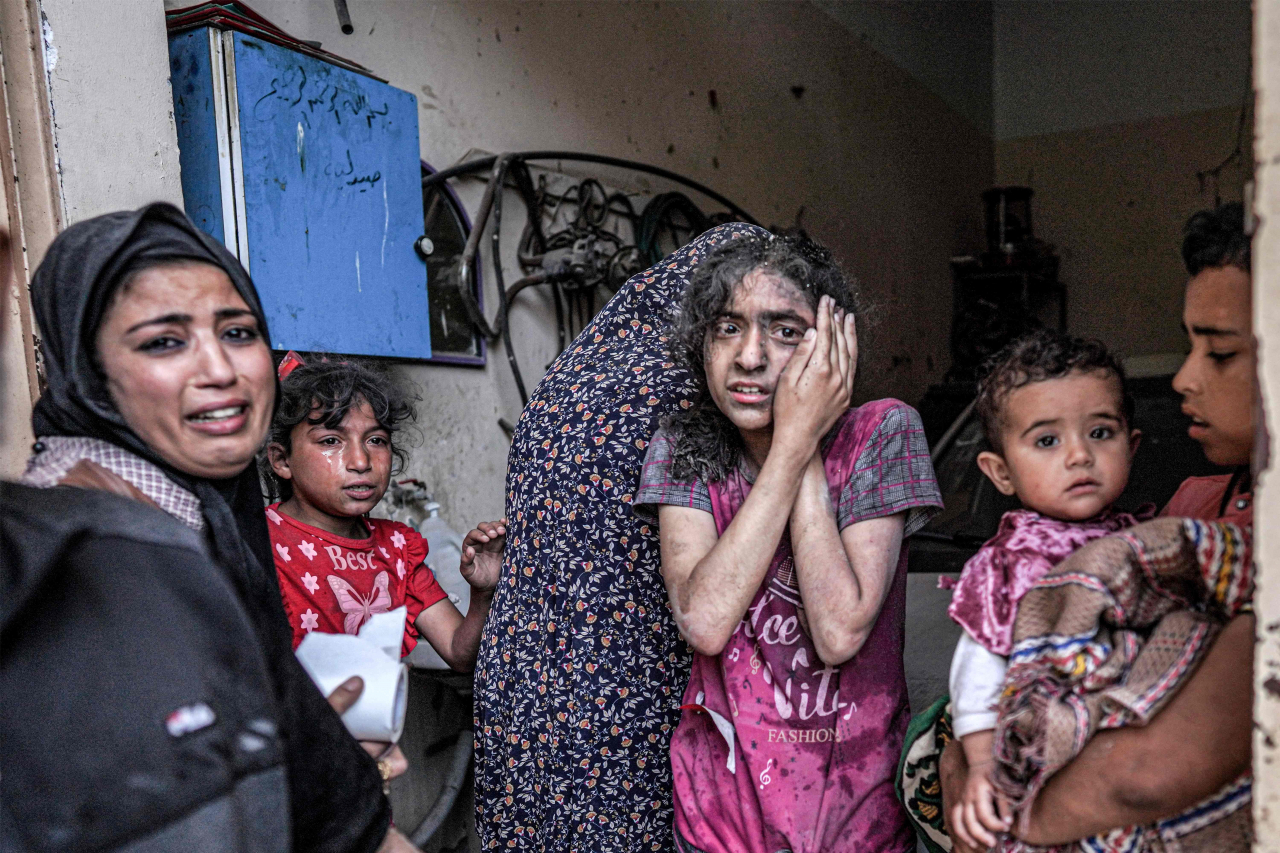 A woman and children are in shock following the Israeli bombardment of Nuseirat in the central Gaza Strip on Monday. (AFP-Yonhap)