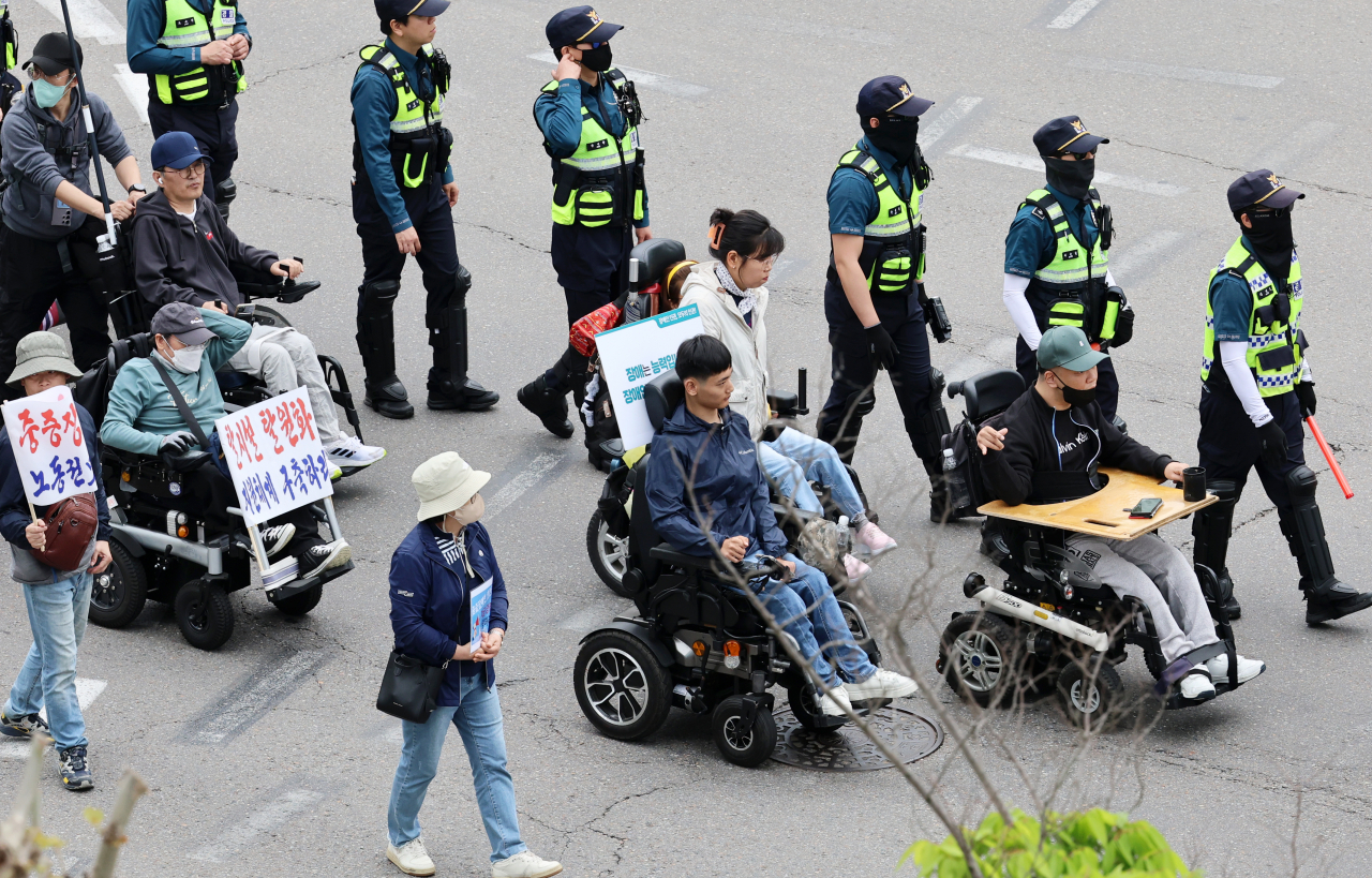 Members of the Solidarity Against Disability Discrimination’s Gwangju Branch march in Seo-gu, Gwangju for the rights of people with disabilities to live, on April 23. (Yonhap)
