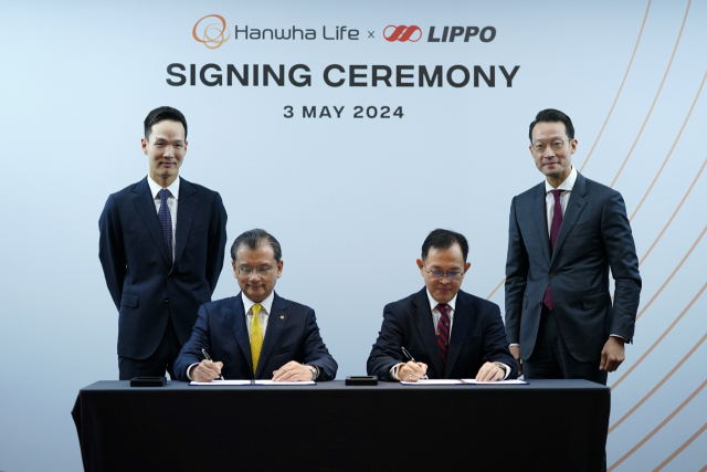 Hanwha Life Vice Chair and CEO Yeo Seung-joo (center left) and Lippo Group’s MPC CEO Adrian Sherman (center right) sign an agreement at a signing ceremony, held in Jakarta, on Friday, also attended by Hanwha Life President and Chief Global Officer Kim Dong-won (far left) and Lippo Group CEO John Riady. (Hanwha Life)