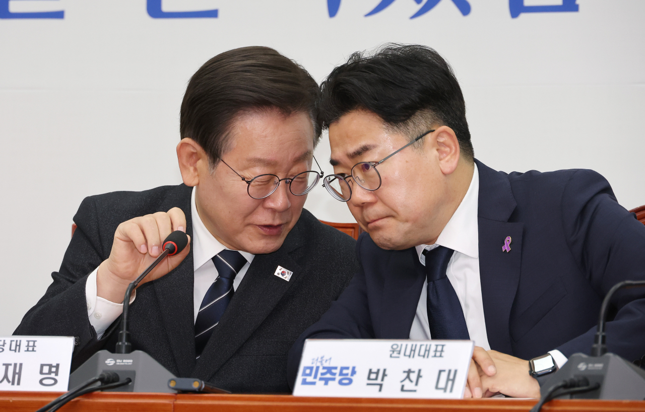 Lee Jae-myung (left), head of the main opposition Democratic Party, and DP floor leader Park Chan-dae engage in a conversation during a meeting of the party's supreme council at the National Assembly in Seoul on Wednesday. (Yonhap)