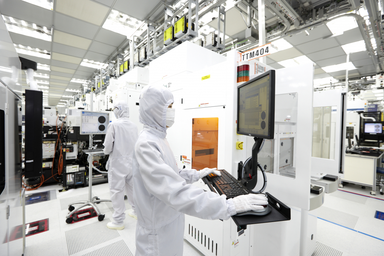 Employees work at a SK hynix semiconductor cleanroom inside the fab. (SK hynix)