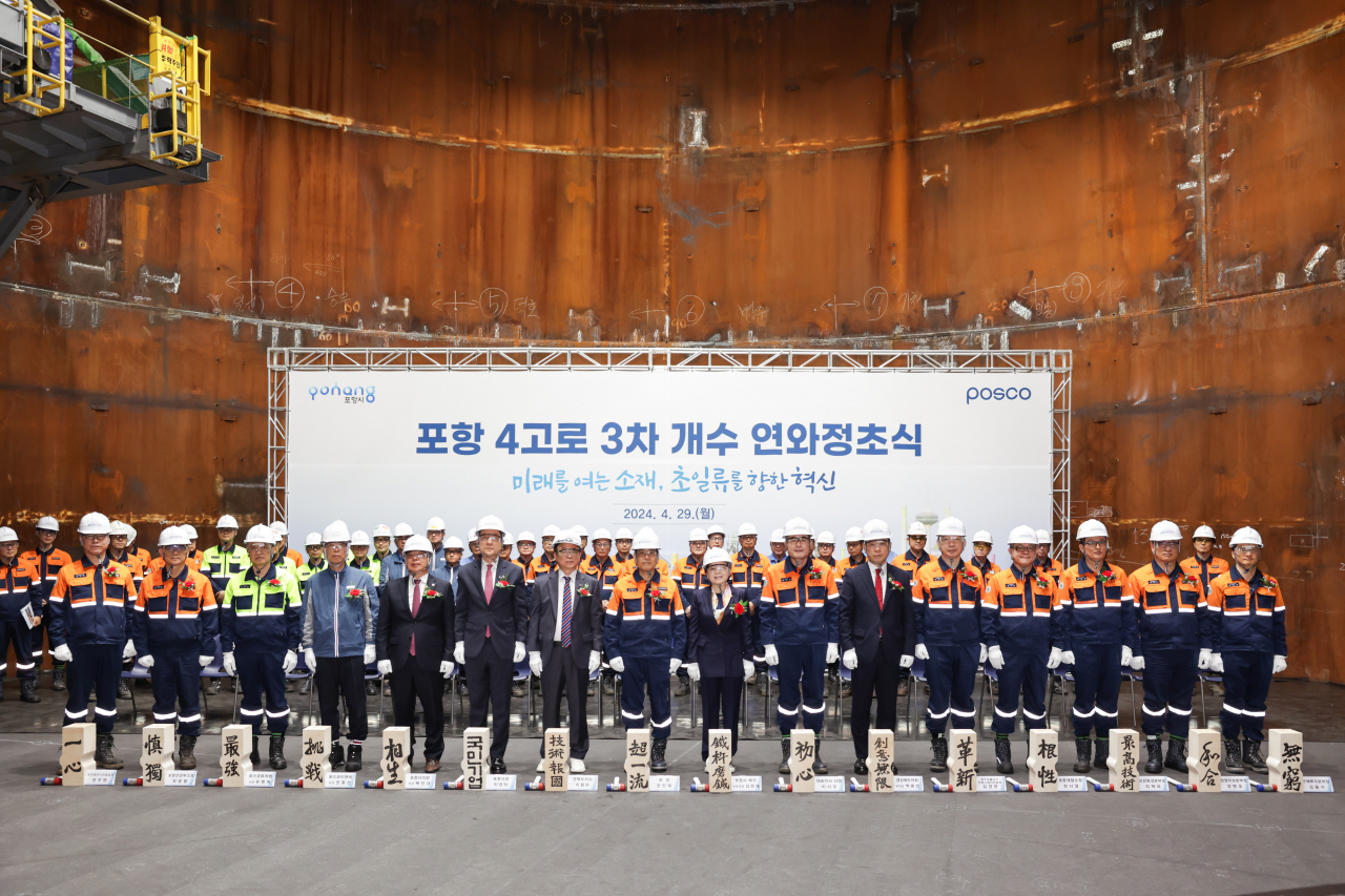 Posco Group CEO Chang In-wha (eighth from left) and company and government officials attend a ceremony celebrating the completion of the third maintenance work of the blast furnace No. 4 at the steel giant’s steel mill in Pohang, North Gyeonsang Province, on April 29. (Posco)