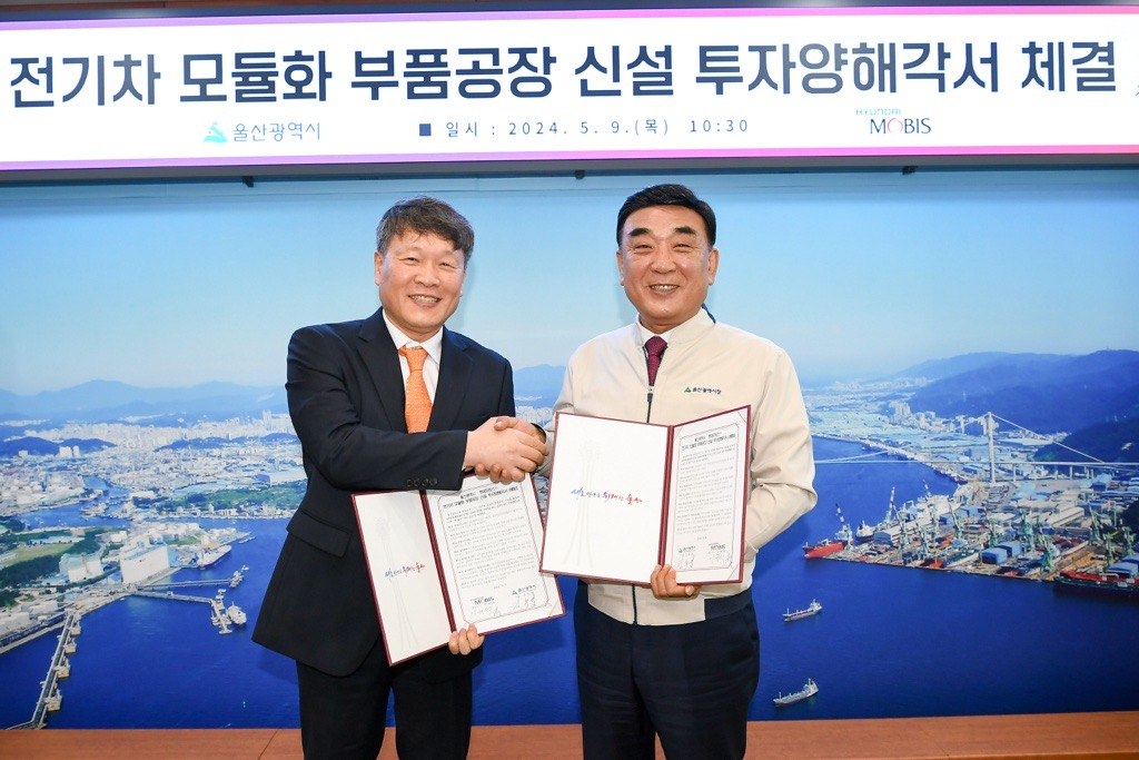 Hyundai Mobis CEO Lee Gyu-suk (left) and Ulsan Mayor Kim Du-gyeom shake hands after signing an agreement for the new EV module plant at Ulsan Metropolitan City Hall on Thursday. (Hyundai Mobis)