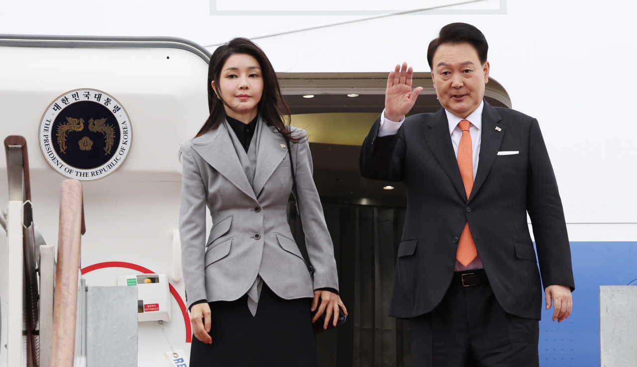 South Korean President Yoon Suk Yeol (Right), alongside his wife, Kim Keon Hee, waves at an airport in Seongnam, south of Seoul, on Dec. 11, 2023, for state visit to Netherlands. (Yonhap)