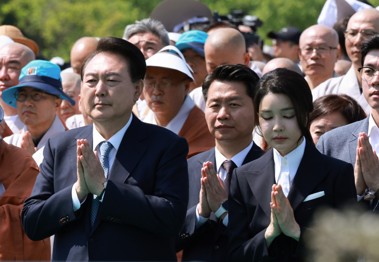 President Yoon Suk Yeol (left, front row) and first lady Kim Keon Hee (second from left, front row) pray at a ceremony held to celebrate the return of 14th-century Buddhist relics to Hoeamsa, a temple in Gyeonggi Province, Sunday. (Yonhap)