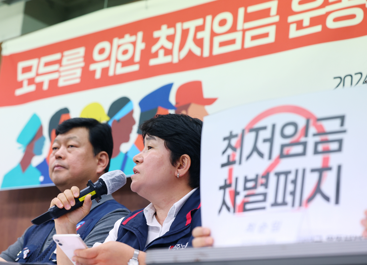 Labor union officials demand a rise in the 2025 minimum wage during a press conference on Monday. (Yonhap)