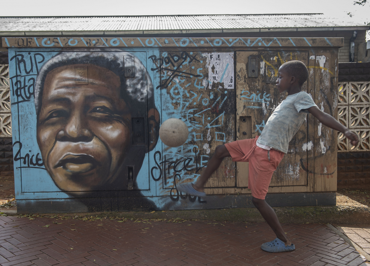 A child kicks a football in front of a mural of Nelson Mandela, in Soweto, South Africa, as the country celebrates Freedom Day on April 27. (AP)