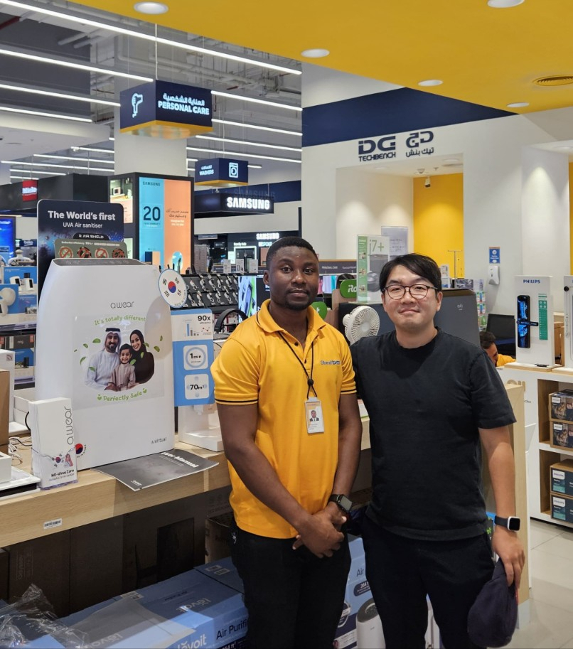 A.Virtual's MENA General Director Lee Sang-wook (right) and a local sales employee pose in front of A.Virtual's sales booth located in a Sharaf DG store. (A.Virtual)