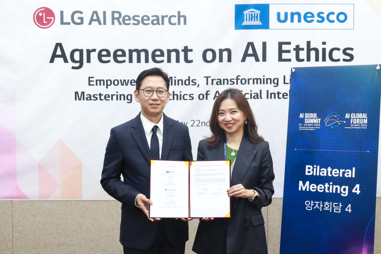 Bae Kyung-hoon (left), chief of LG AI Research, and Kim Soo-hyun, director of the UNESCO Asia and Pacific, pose for a photo after signing an agreement on AI ethics at the Korea Institute of Science and Technology in Seoul on Wednesday.