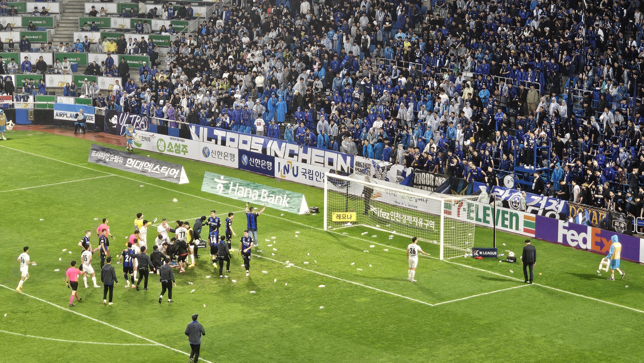 Players from Incheon United and FC Seoul try to stop fans from throwing water bottles onto the field after their K League 1 match at Incheon Football Stadium in Incheon, just west of Seoul, in this file photo taken May 11, 2024. (Yonhap)