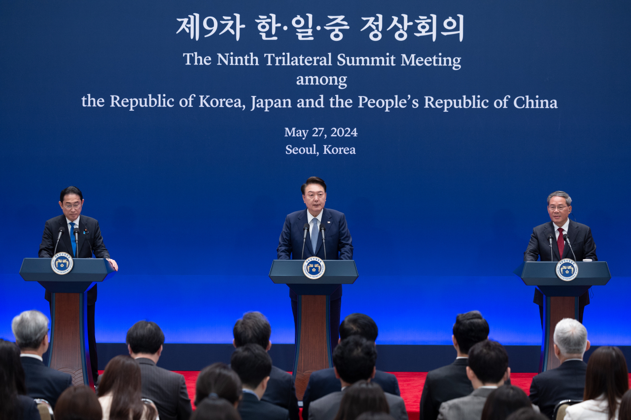 President Yoon Suk Yeol (center) speaks during a joint press briefing of the ninth trilateral summit with Japanese Prime Minister Fumio Kishida (left) and Chinese Premier Li Qiang at the former presidential office of Cheong Wa Dae in Seoul on Monday. (Yonhap)