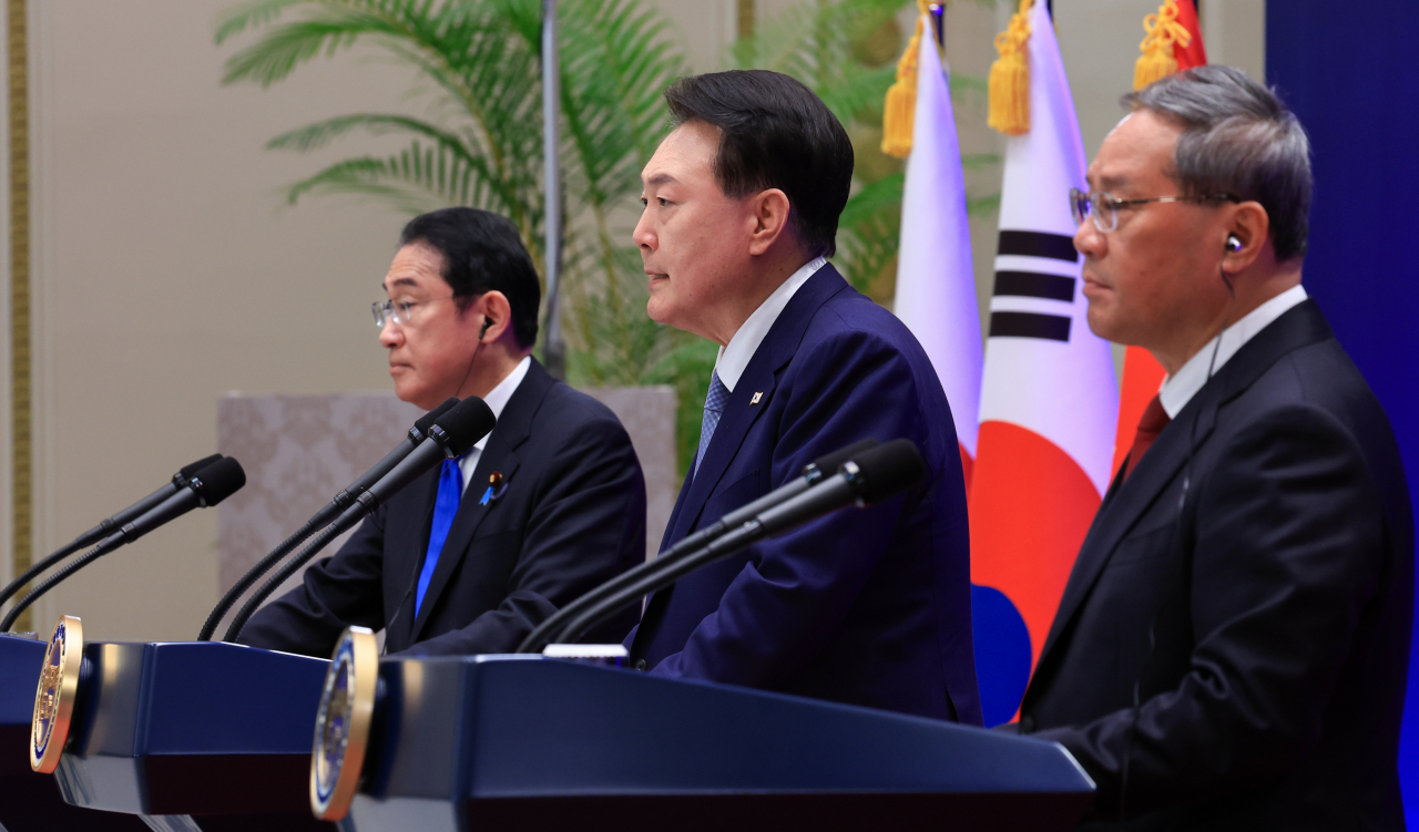 South Korean President Yoon Suk Yeol (center) speaks during a joint news conference with Japanese Prime Minister Fumio Kishida (left) and Chinese Premier Li Qiang at the guesthouse of the former presidential office, Cheong Wa Dae, in Seoul on Monday. (Presidential Office)