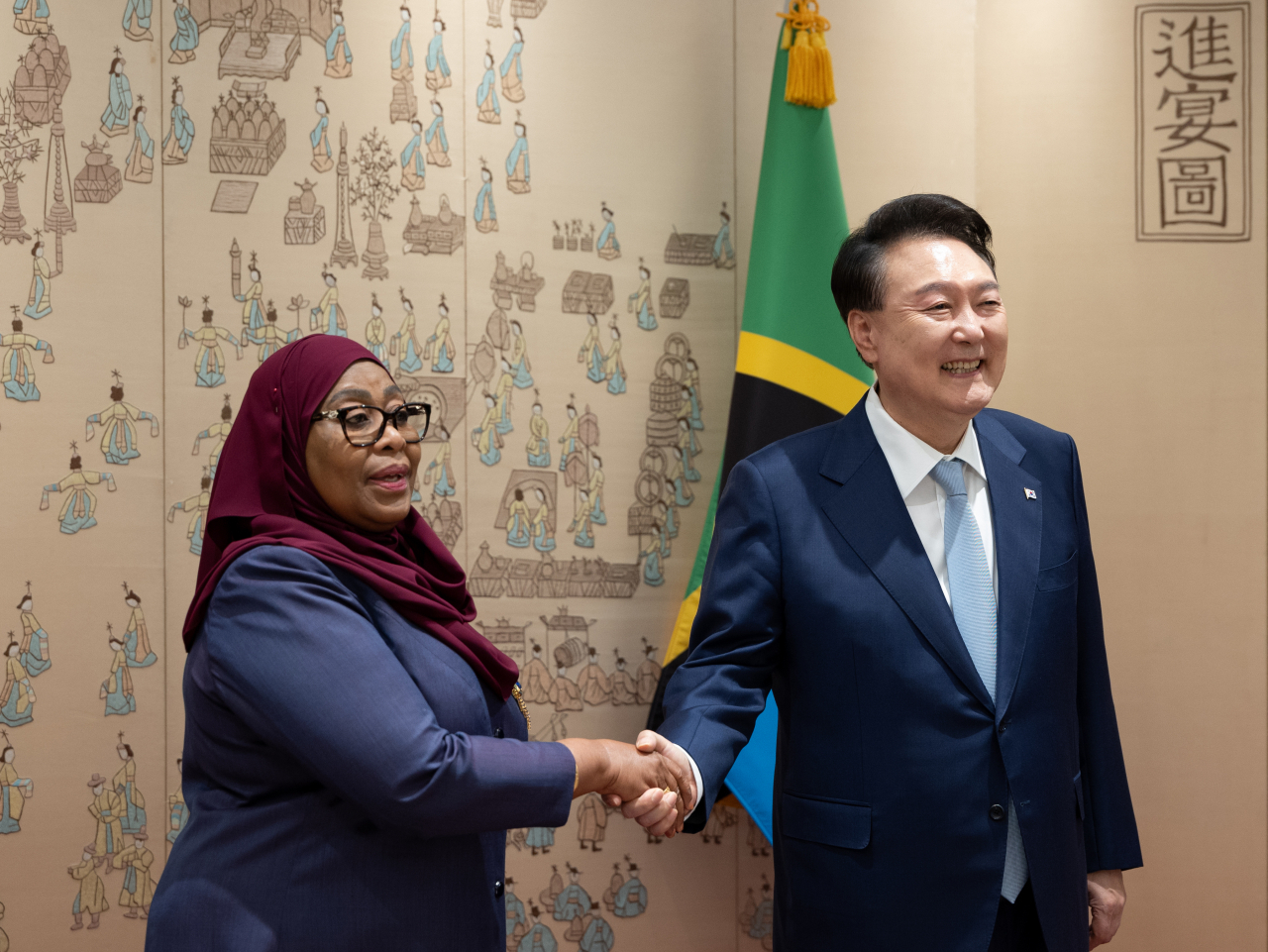 President Yoon Suk Yeol shakes hands with Tanzanian President Samia Suluhu Hassan during a summit held in the presidential office in Seoul on Sunday, (Presidential Office)