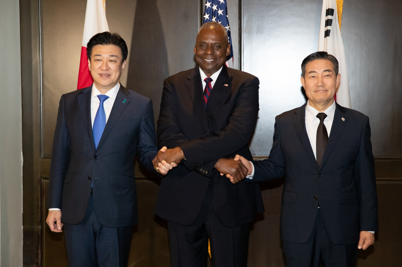 Japan’s Minister of Defense Minoru Kihara (from left), US Secretary of Defense Lloyd Austin and South Korean Defense Minister Shin Won-sik pose for a photo for a trilateral meeting held on the last day of the annual Shangri-La Dialogue defense summit in Singapore.on Sunday. (Pool photo by Yonhap)
