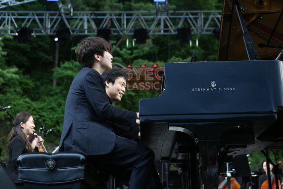 Pianist Cho Seong-jin (front) and conductor-pianist Kim Sun-wook perform Brahms' Hungarian Dance No. 5 at the 10th Gyechon Classic Festival on Sunday. (Chung Mong-koo Foundation)