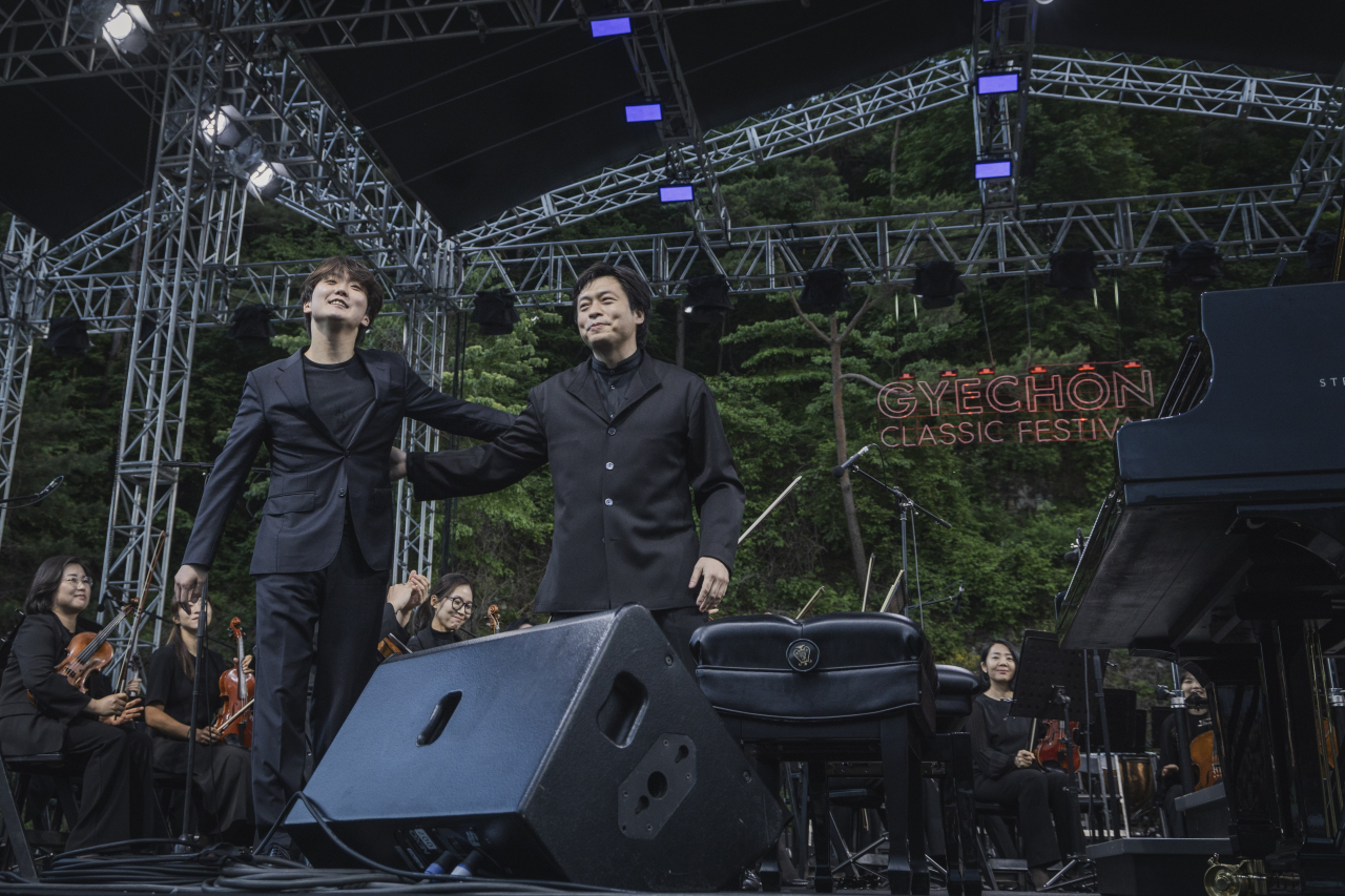 Pianist Cho Seong-jin (left) and conductor-pianist Kim Sun-wook greet the audience after performing Brahms' Hungarian Dance No. 5 at the 10th Gyechon Classic Festival on Sunday. (Chung Mong-koo Foundation)