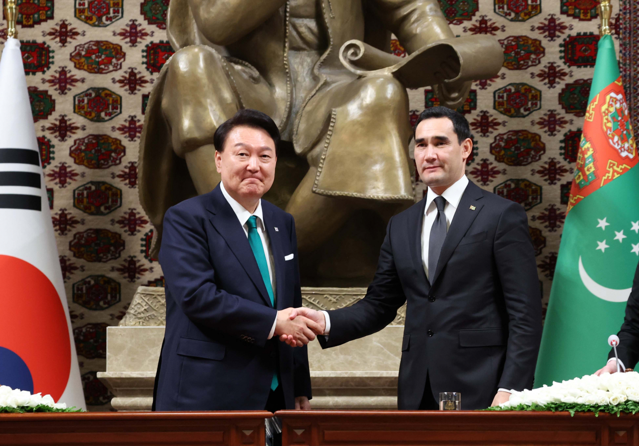 President Yoon Suk Yeol (left) and Turkmen President Serdar Berdymukhamedov shake hands at the summit held at the Oguzkhan Presidential Palace in Ashgabat, Turkmenistan on Monday. (Yonhap)
