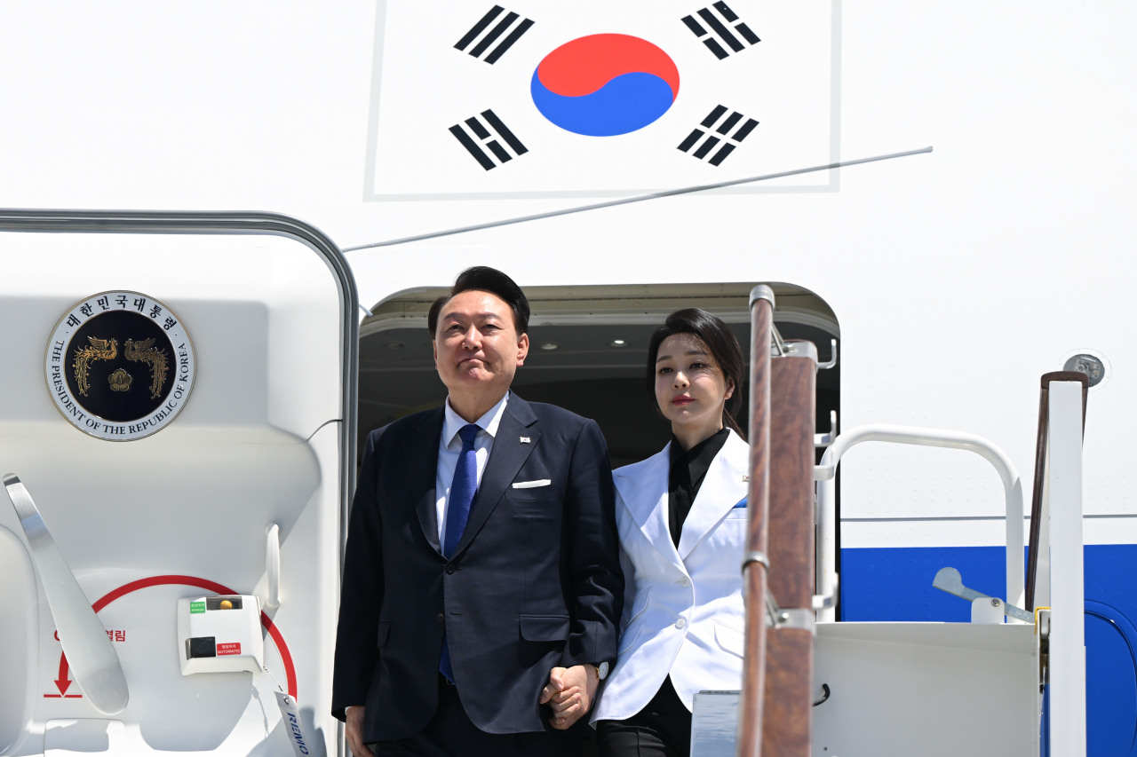 President Yoon Suk Yeol (left) and first lady Kim Keon Hee disembark from the Air Force One as they arrived at Tashkent, Uzbekistan on Thursday for a state visit. (Yonhap)