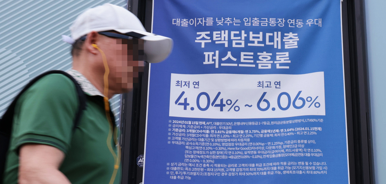 A man passes by a sign about a bank's loan progrmas in Seoul on Wednesday. (Yonhap)