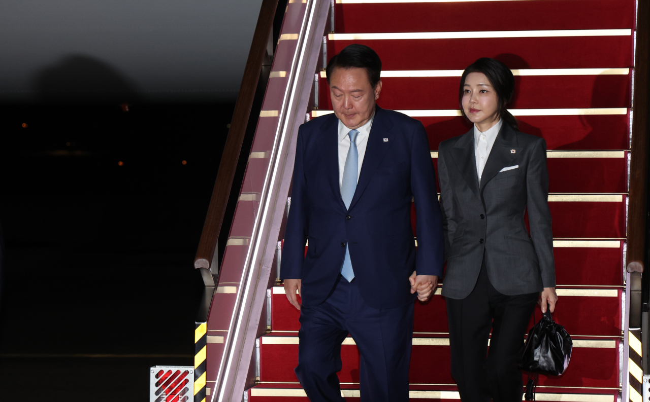 President Yoon Suk Yeol (left) and first lady Kim Keon Hee disembark from the Air Force One at Seoul Air Base in Seongnam, Gyeonggi Province, Sunday. (Yonhap)