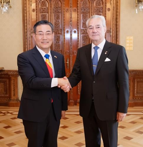 South Korean Defense Minister Shin Won-sik (L) shakes his hands with Romania's presidential adviser on national security Ion Oprisor during his visit to the East European nation in this photo provided by Shin's office on June 18, 2024. (PHOTO NOT FOR SALE) (Yonhap)