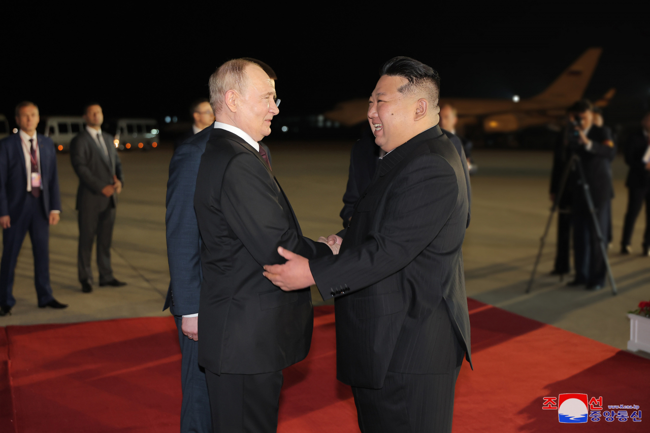 Russian President Vladimir Putin is greeted by North Korean leader Kim Jong-un during a welcoming ceremony at an airport in Pyongyang on Wednesday. (KCNA)