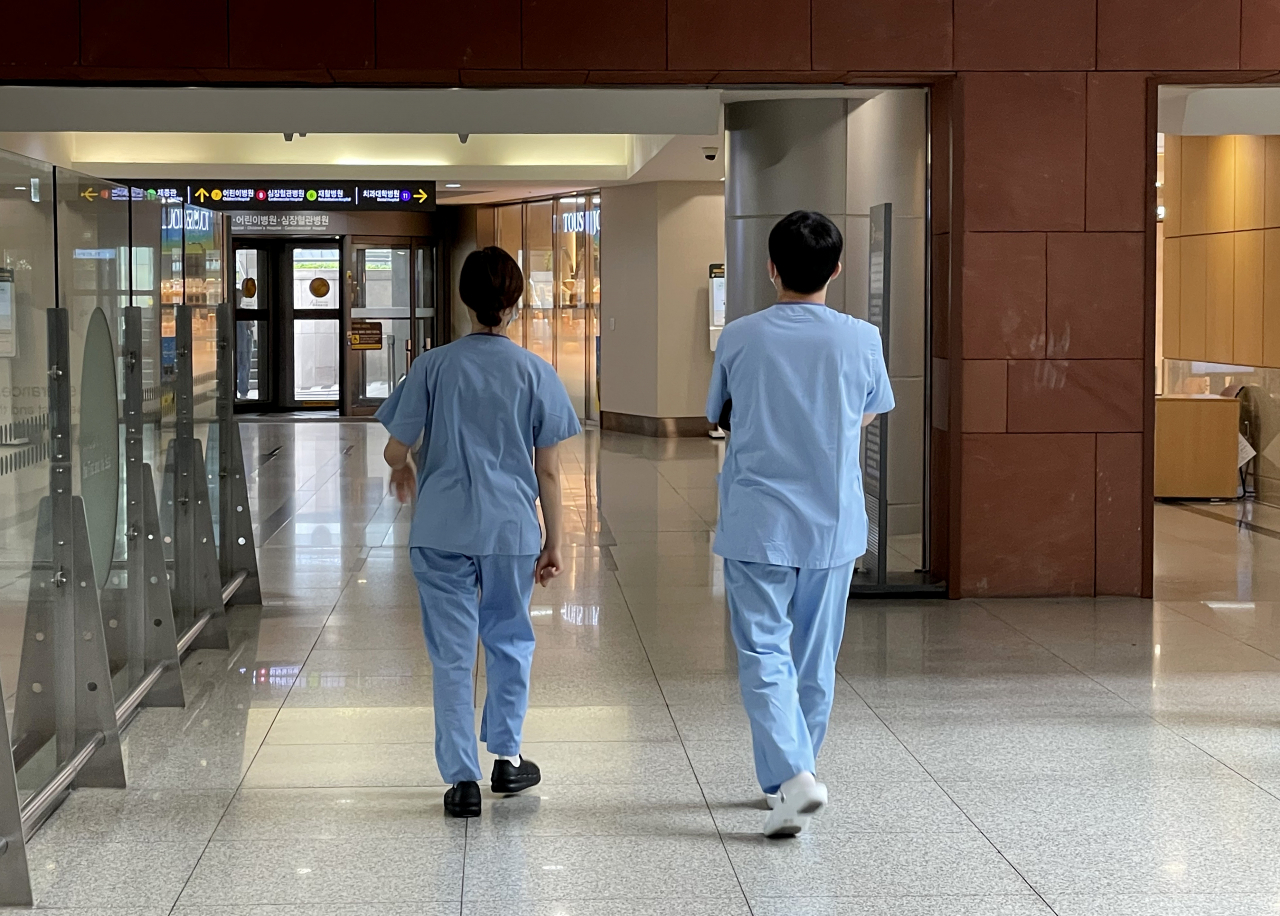 Medical workers walk in a hallway at a university hospital in Seoul on Sunday (Yonhap)