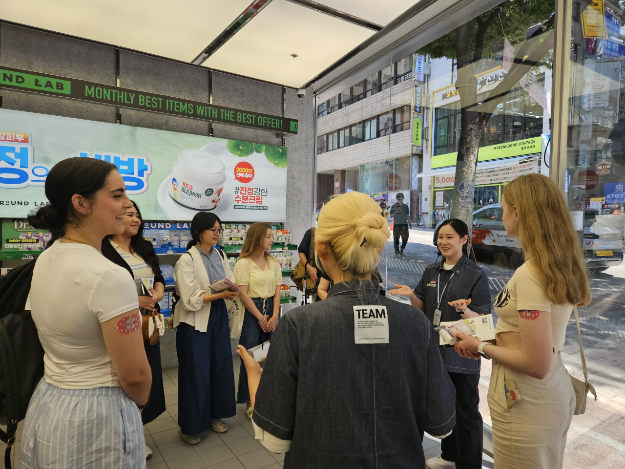Participants listen to an Olive Young staff member's instructions for its K-beauty docent program at a branch in Myeong-dong, Seoul, Wednesday. (Kim Hae-yeon/The Korea Herald)