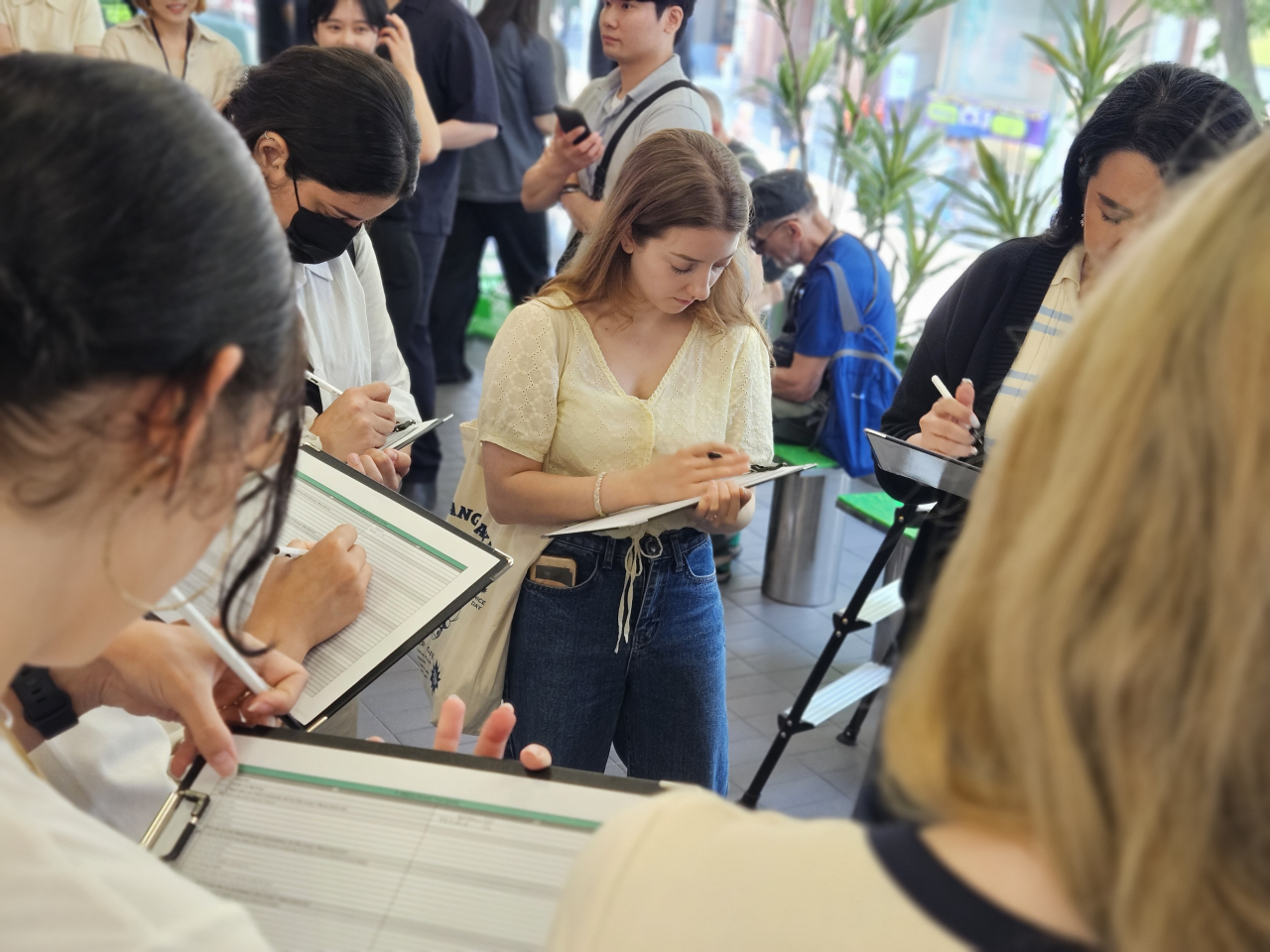 K-beauty docent program participants fill out a survey after an hourlong tour on Wednesday. (Kim Hae-yeon/The Korea Herald)