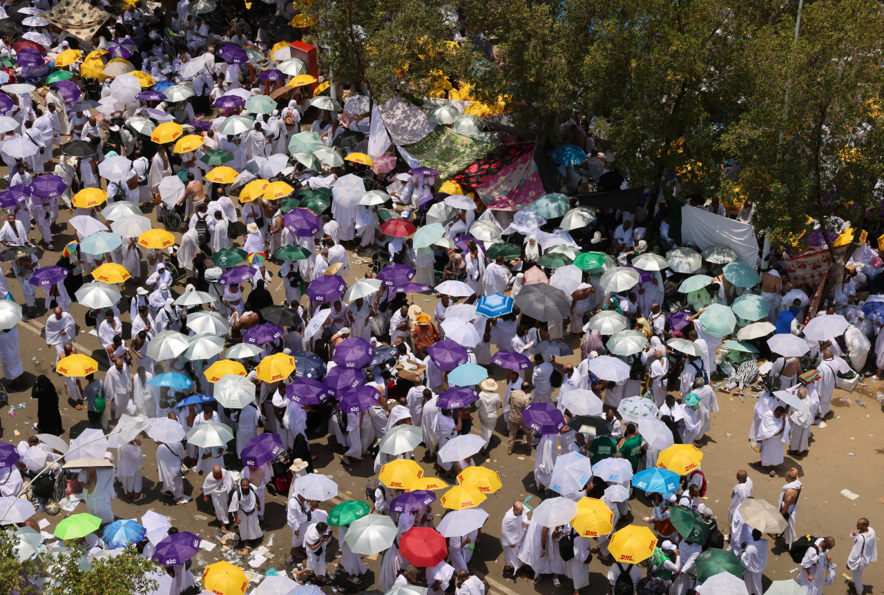 Muslim pilgrims use umbrellas to shield themselves from the sun as they gather to attend noon prayers outside Nimrah Mosque at the Plain of Arafat, outside the holy city of Mecca, Saudi Arabia, Jun. 15. (Reuters-Yonhap)