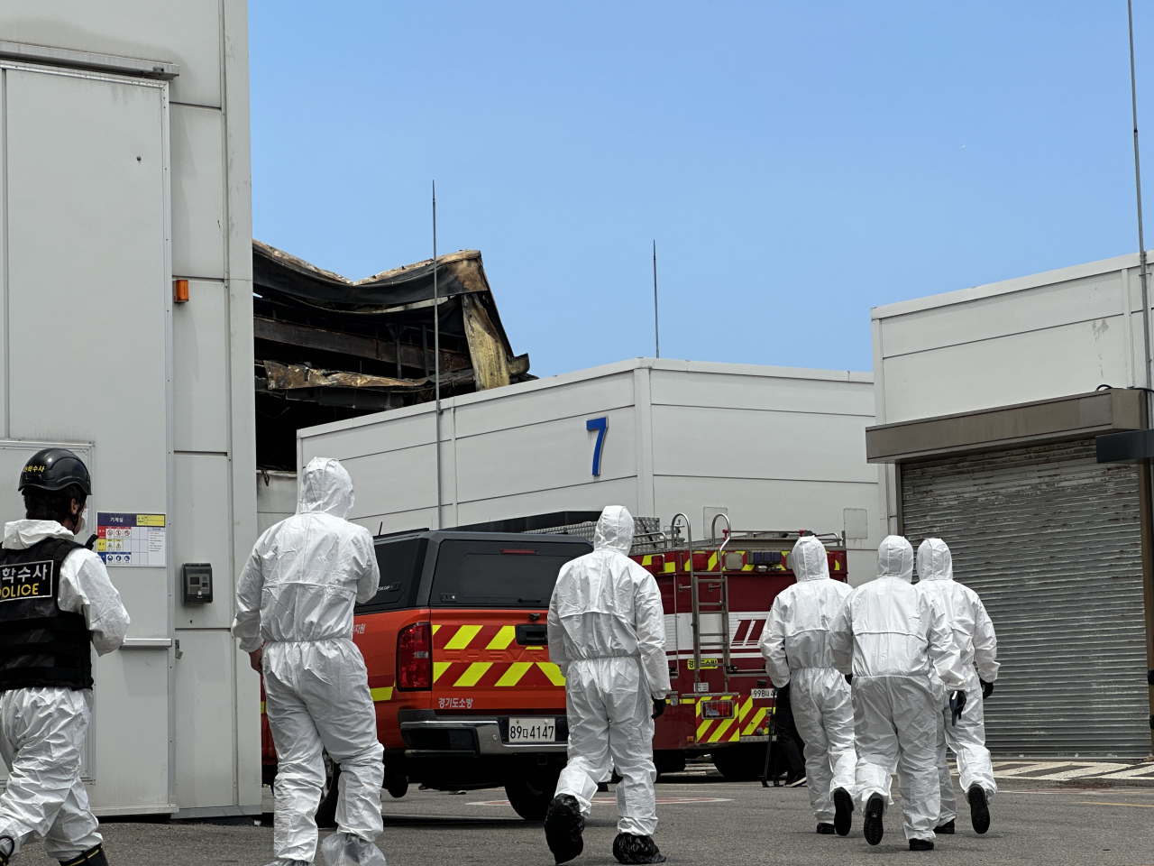 Officials conducting forensics operations make their way toward the Aricell Factory in Hwaseong, Gyeonggi Province, at noon on Tuesday. The first round of forensics operations in the factory lasted around 4 hours. (Lee Jung-joo/The Korea Herald)