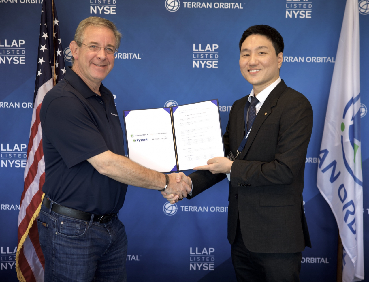Ahn Tae-hun (right), CEO of Flexell Space, and Marc Bell, CEO of Terran Orbital, shake hands after signing a memorandum of understanding on June 25. (Hanwha Systems)