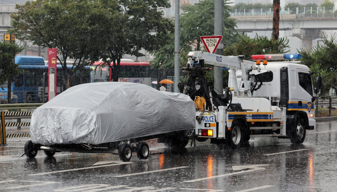 A car of the driver responsible for Monday's deadly accident, which left nine dead and four injured, is being towed by a police tow truck Tuesday in Seoul. (Yonhap)
