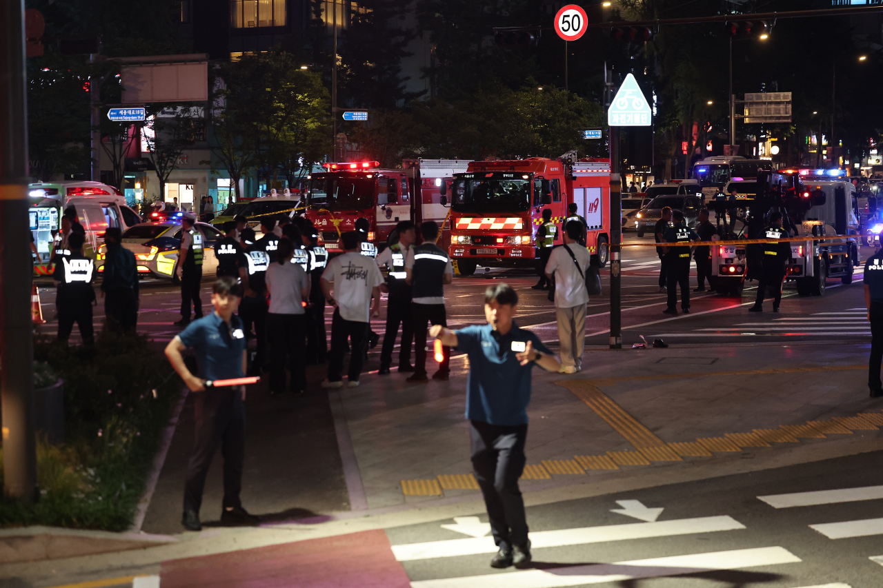 Officials handle the scene of the deadly car crash in central Seoul late Monday (Yonhap)