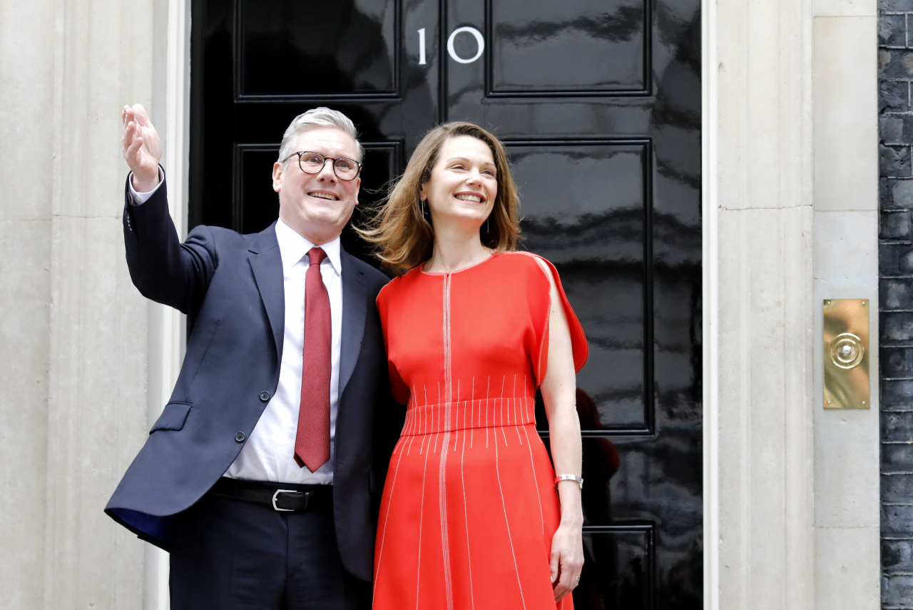 Britain's new Prime Minister Keir Starmer (left) and his wife Victoria Starmer wave to the media on the steps of 10 Downing Street in London on Friday. (EPA-Yonhap)