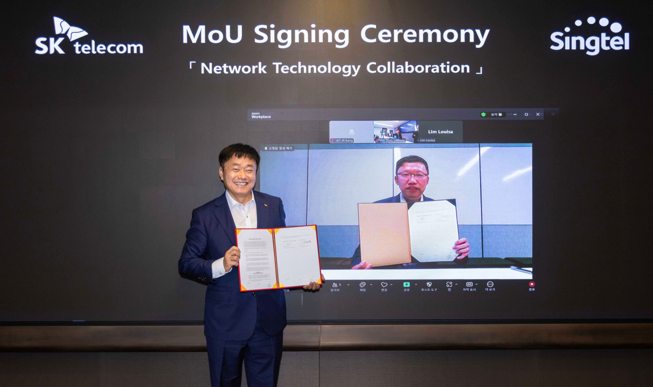 Kang Jong-ryeol, head of ICT infra at SK Telecom (left) and Tay Yeow Lian, managing director of networks at Singtel, pose after signing a memorandum of understanding to collaborate on next-generation network technologies. (SK Telecom)