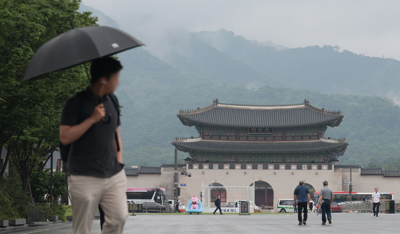 A pedestrian walks with an umbrella near Gwanghwamun Square in Seoul on Monday. (Yonhap)