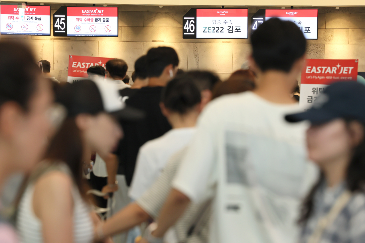 Passengers line up for check in at Jeju International Airport in Jeju on Friday. Travelers in South Korea, as in other parts of the world, were inconvenienced by a major internet outage that disrupted flightts and other businesses. (Yonhap)