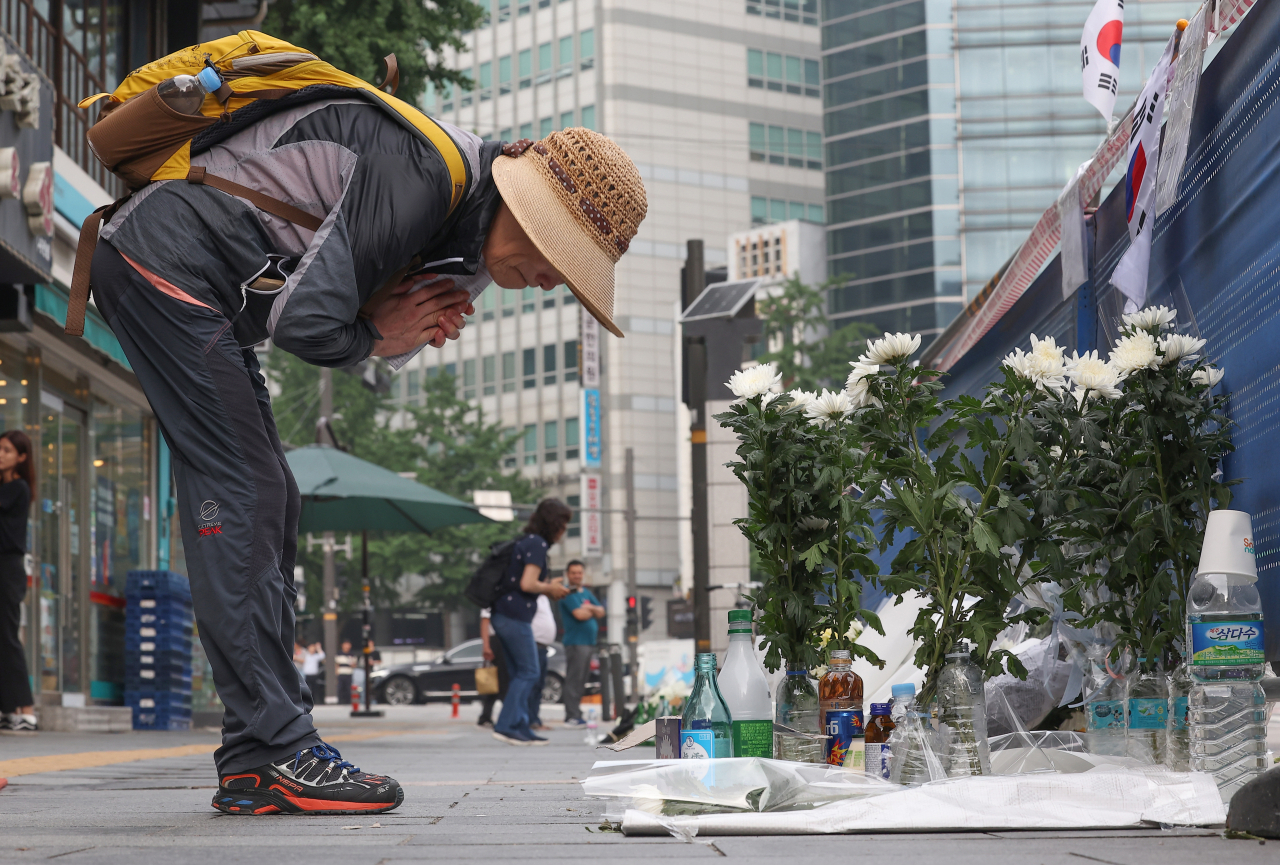 A pedestrian offers a condolence prayer at a makeshift memorial near Exit No. 7 of City Hall Station on July 4, three days after the deadly car crash that resulted in nine casualties. (Yonhap)