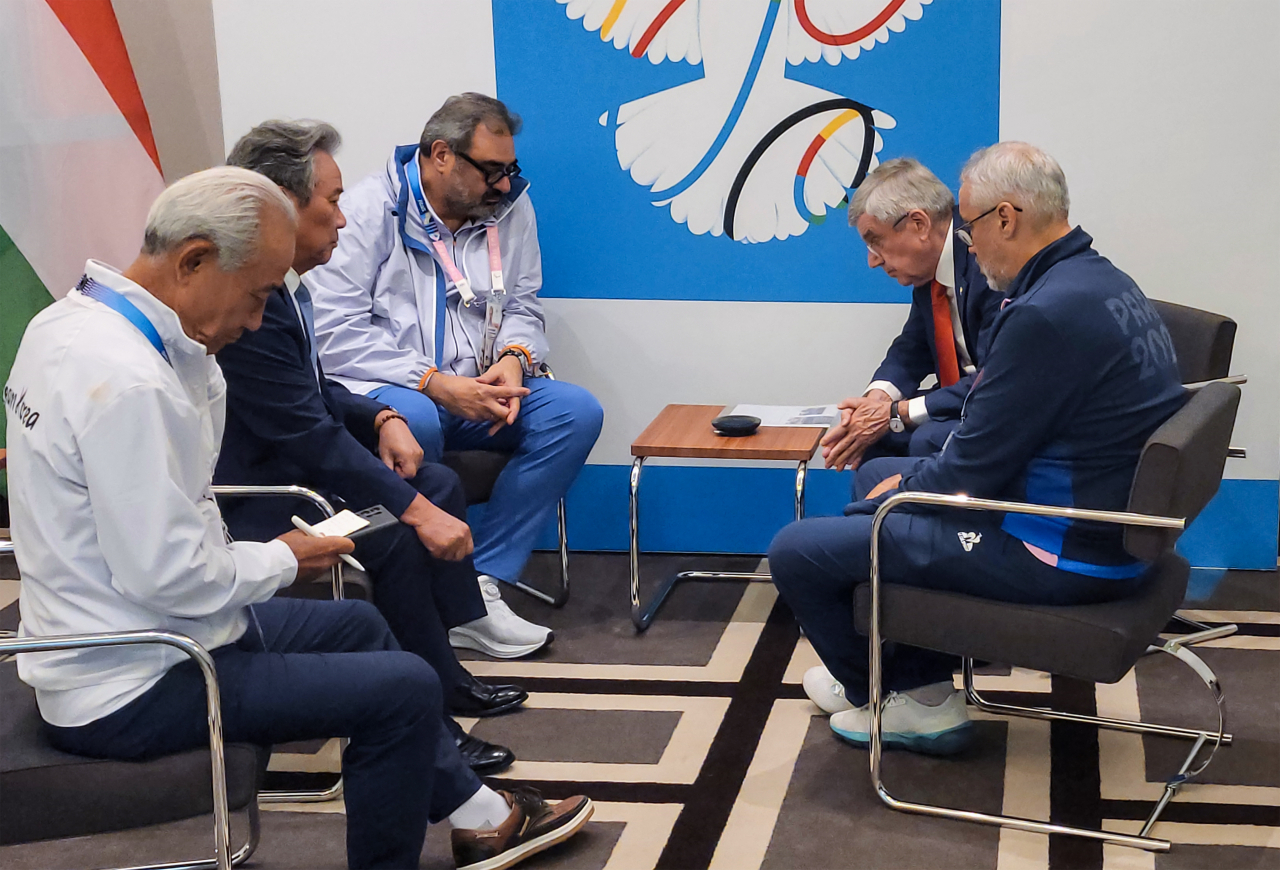 In this photo provided by the Korean Sport & Olympic Committee, Thomas Bach (center, seated by the wall), president of the International Olympic Committee, speaks with South Korean President Yoon Suk Yeol in Paris on Saturday, to apologize for an incident during the opening ceremony of the Paris Olympics in which South Korea was mistakenly introduced as North Korea. (Yonhap)