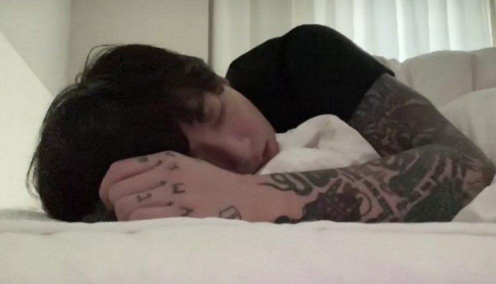 Jungkook of BTS is seen sleeping in this screen-capture from his livestream with fans on Weverse in June 2023. (Jungkook's Weverse channel)