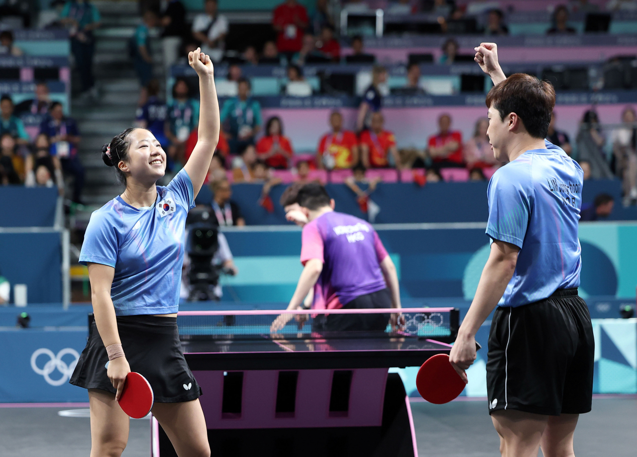 Shin Yu-bin (left) and Lim Jong-hoon of South Korea celebrate a point against Wong Chun Ting and Doo Hoi Kem of Hong Kong during the bronze medal match in the mixed doubles table tennis event at the Paris Olympics at South Paris Arena 4 in Paris on Tuesday. (Yonhap)