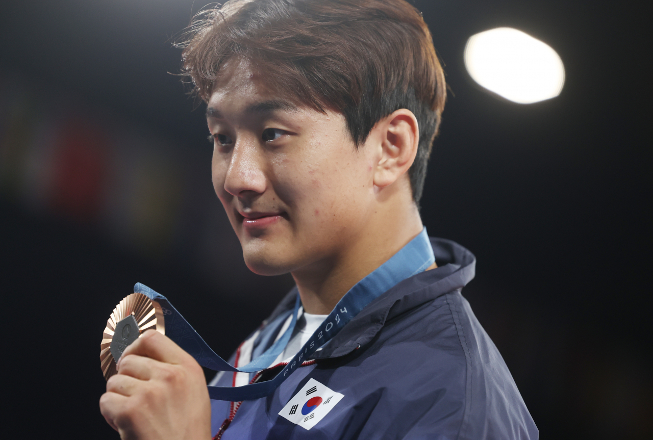 Lee Joon-hwan of South Korea holds up his bronze medal won in the men's -81-kilogram judo event at the Paris Olympics at Champ-de-Mars Arena in Paris on Tuesday. (Yonhap)