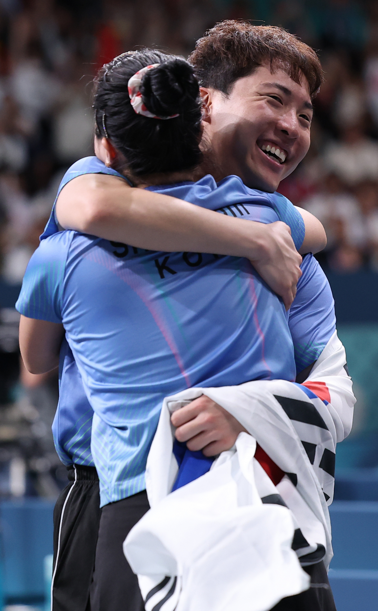 Lim Jong-hoon (right) embraces Shin Yu-bin after the duo won the bronze medal match in the mixed doubles table tennis event at the Paris Olympics on Tuesday. (Yonhap)