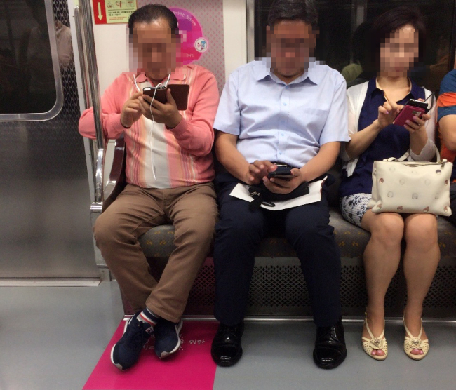 A priority seat designated for pregnant women (marked in pink) is <strong></strong>occupied in a Seoul subway car. (The Korea Herald)