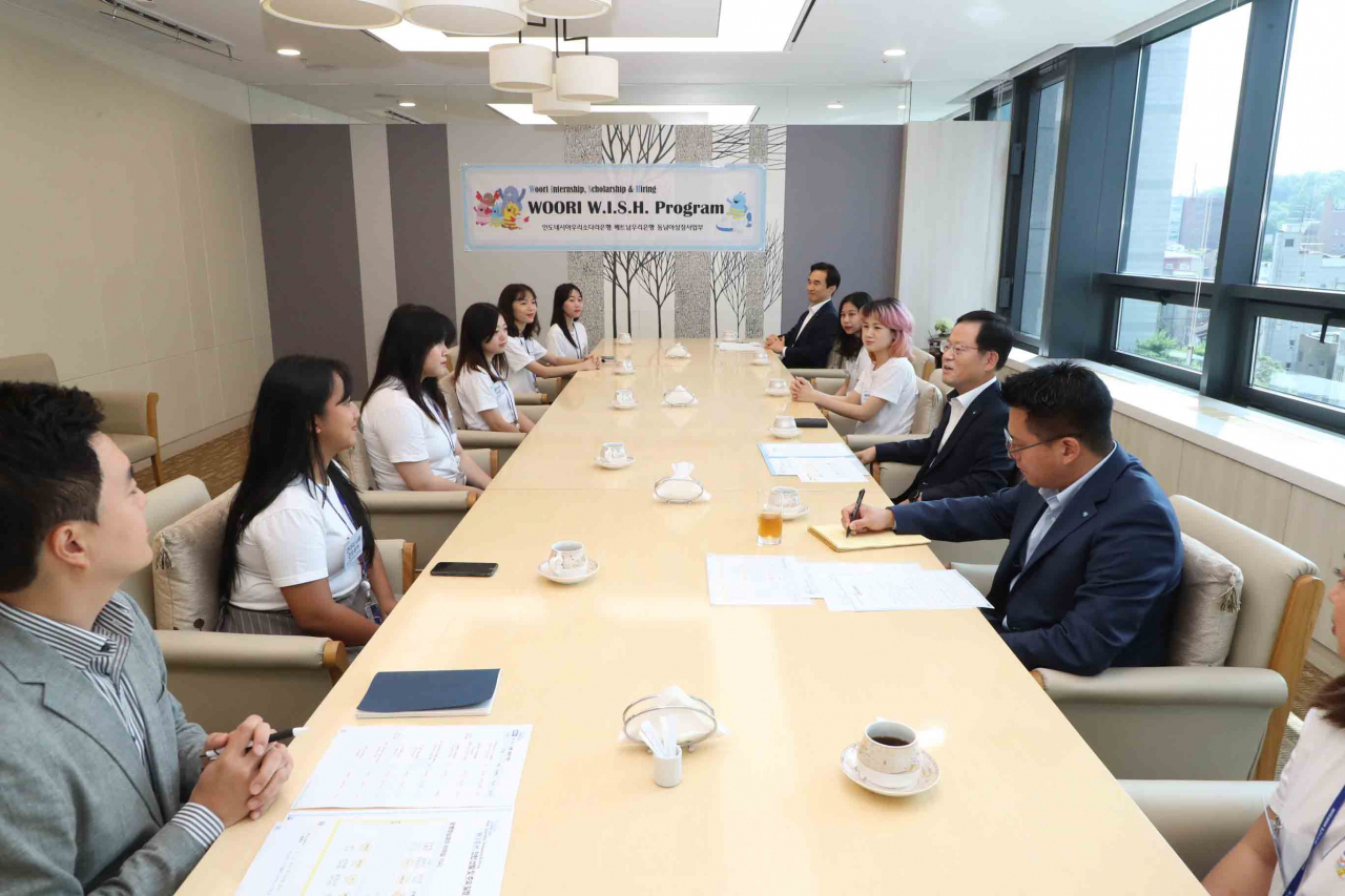 Woori Bank's foreign interns hold a meeting with CEO Cho Byung-kyu (second from right) at the bank's headquarters in central Seoul. (Woori Bank)